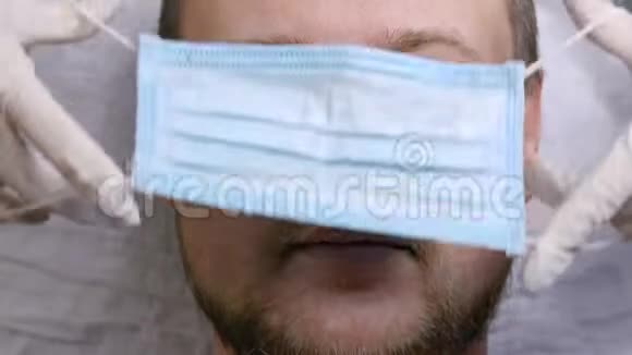 护士给一个男人戴上一个保护性的医疗面罩该流行病病毒处于恐慌状态护士医生危险视频的预览图