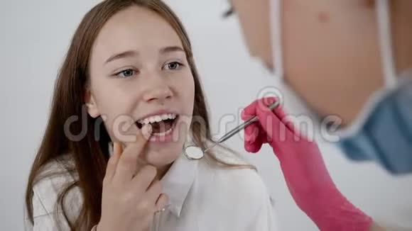 牙科医生使用牙科工具检查病人口腔戴手套的手特写视频的预览图
