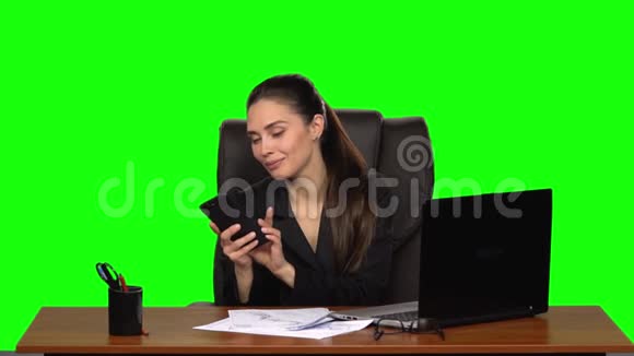 女商人在工作场所打电话调情绿色屏幕慢动作视频的预览图
