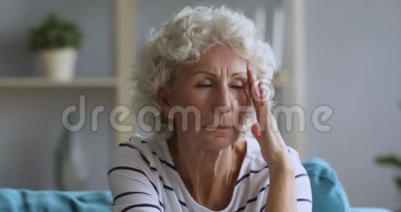 疲惫的成熟老年女性养老金领取者头痛视频的预览图