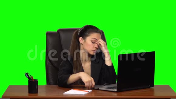 疲惫的女孩手里拿着眼镜在笔记本电脑上工作然后享受她在屏幕上看到的东西绿色屏幕慢慢视频的预览图