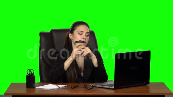 商务女性坐在办公桌前坐在皮椅上然后在笔记本电脑上喝咖啡绿色屏幕工作室慢慢视频的预览图