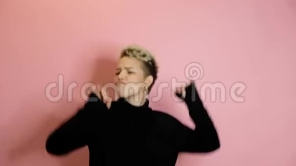 快乐无忧无虑时尚的女人在粉红色的背景下跳舞视频的预览图