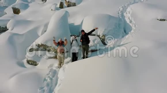 空中飞人射击徒步旅行者挥动双手站在白雪覆盖的山坡上视频的预览图