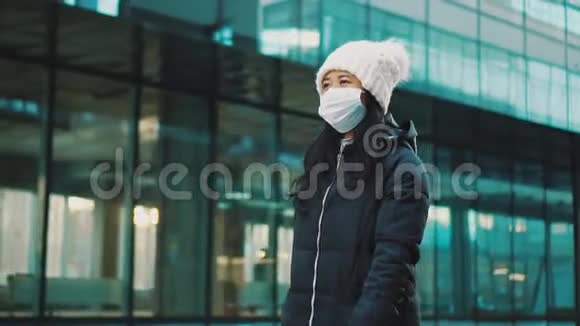 女人走在空荡荡的街道上戴着隔离面具冠状病毒流行视频的预览图