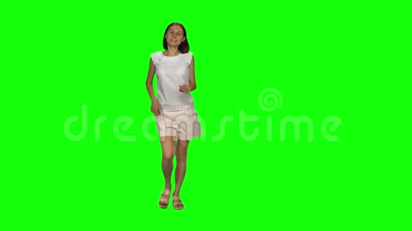 棕色头发和光滑发型的年轻女人正在绿色屏幕上奔跑和挥手停止铬钥匙前景视频的预览图
