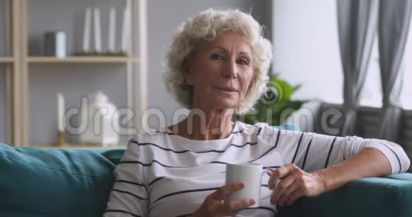 快乐的老奶奶躺在舒适的沙发上视频的预览图