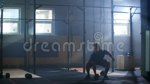 健身房里的一个男人在慢动作中表演一个拉起的哑铃视频的预览图