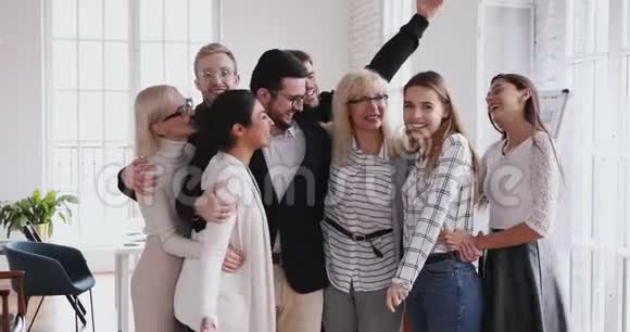 年长的女领导团结年轻的员工拥抱着办公室里的笑声视频的预览图