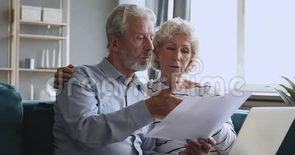 一位年长的男人在家里和妻子讨论每月的开支视频的预览图