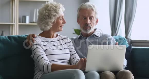 严肃的中年男人向妻子解释新的电脑软件视频的预览图