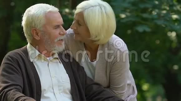 公园里满是皱纹的男人和女人温柔地接吻幸福和爱视频的预览图