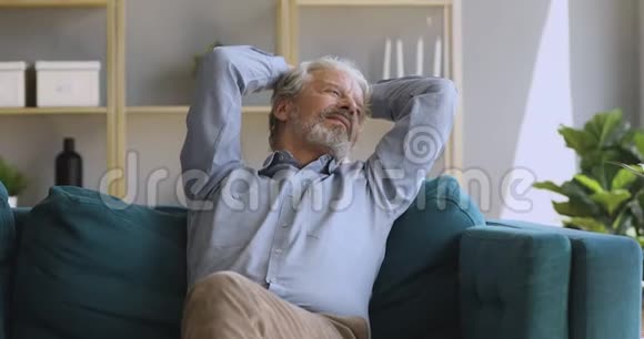 快乐无忧无虑的中年男人独自在舒适的沙发上放松视频的预览图