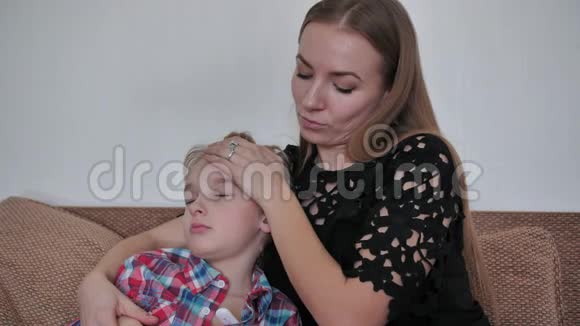 有爱心的母亲用温度计测量儿子的体温视频的预览图