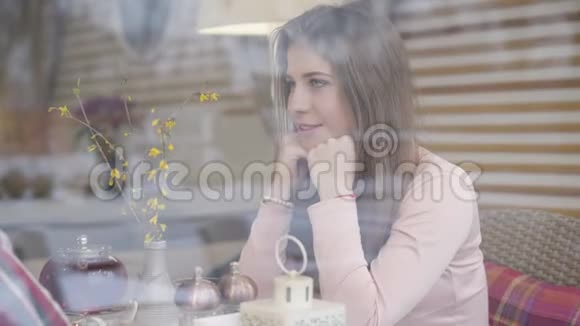 侧面的肖像迷人的白种人年轻妇女坐在桌子旁的咖啡馆和某人交谈美丽美丽视频的预览图