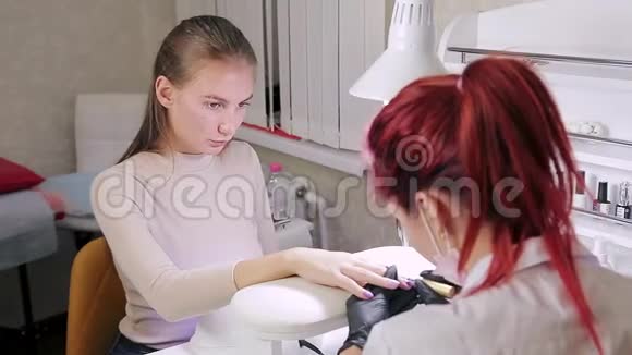 美容院的女美甲师在涂胶上涂了一层哑光视频的预览图
