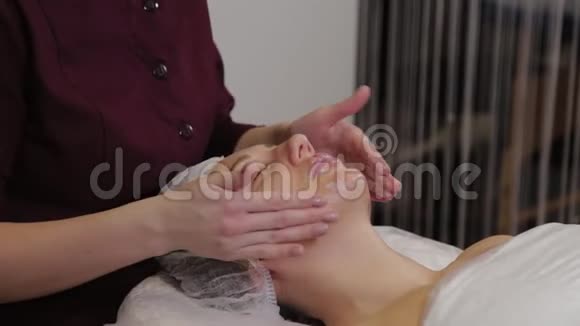 专业美容师女性为美容院客户做面部按摩视频的预览图