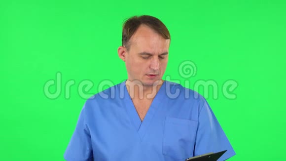 医务人员用pensil在黑色文件夹里填写文件绿色屏幕视频的预览图