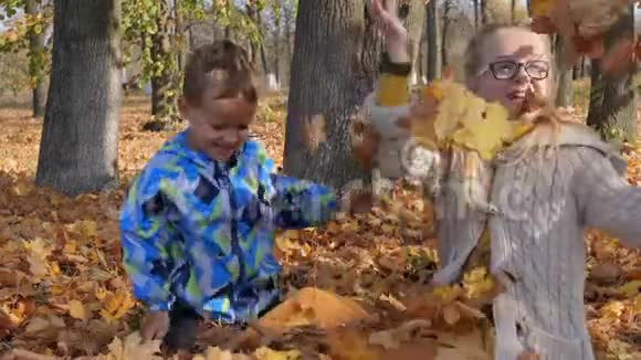 快乐的孩子们玩秋天落叶视频的预览图
