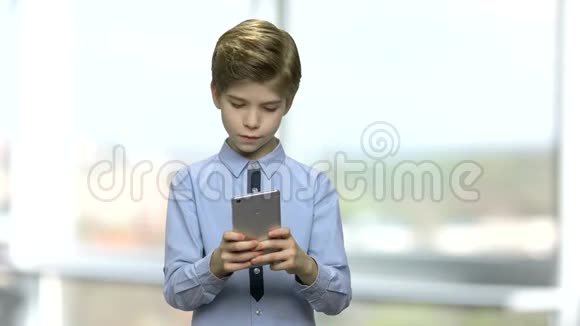 可爱的小男孩使用智能手机视频的预览图
