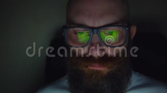 戴眼镜的胡子男深夜浏览网站眼镜反光视频的预览图