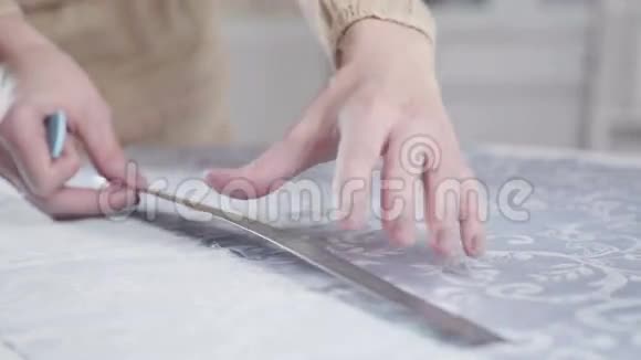 裁缝用粉笔和尺子测量织物的长度视频的预览图