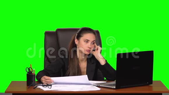 疲惫的女人读文件比较信息与笔记本电脑并揉皱纸绿色屏幕慢动作视频的预览图