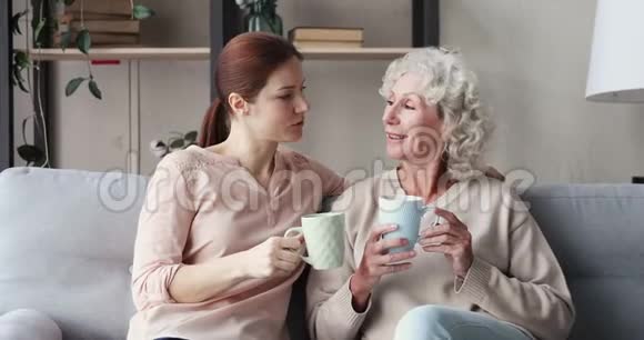 幸福的两代女人一家人在家里聊天喝茶视频的预览图
