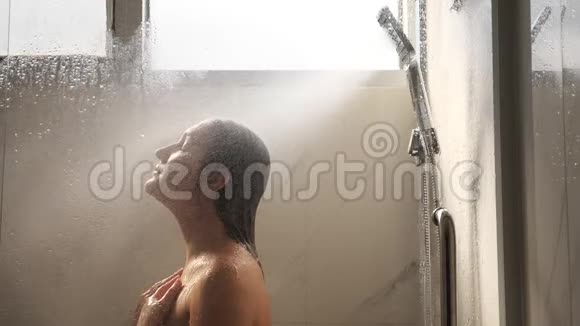 头发湿漉漉的漂亮黑发女人站在淋浴间视频的预览图