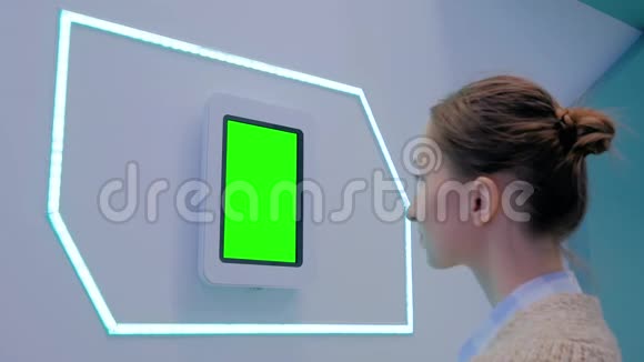 女人看着空白绿色屏幕的平板电脑色度关键概念视频的预览图