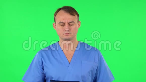 穿着蓝色外套的男医生用x光检查快照绿色屏幕视频的预览图