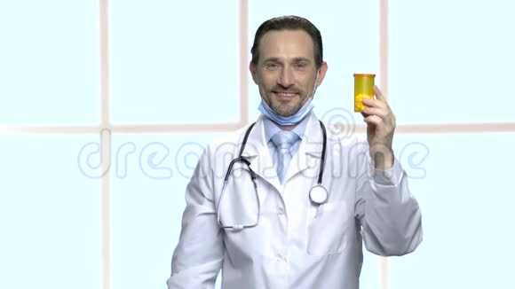 英俊的成熟医生出示一瓶药丸视频的预览图