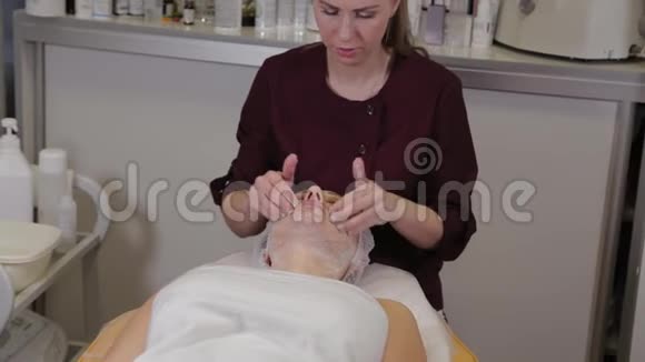 一位专业的美容师用液体肥皂病人的脸上同时按摩视频的预览图