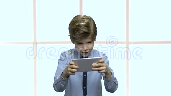 小白种人男孩在智能手机上玩游戏视频的预览图