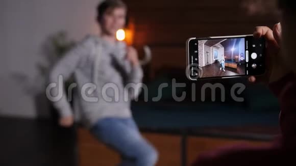 手提手机拍摄跳舞男孩的视频视频的预览图