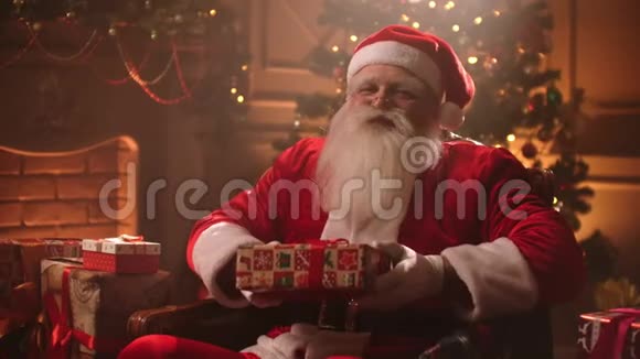 圣诞前夜圣诞老人在一种神奇的气氛中微笑着递给相机一份礼物视频的预览图