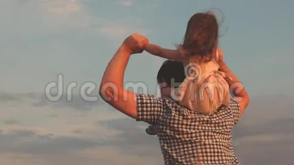 孩子和父母在大自然中玩耍在蓝天的映衬下小快乐的女儿站在父亲的肩膀上小男孩和视频的预览图