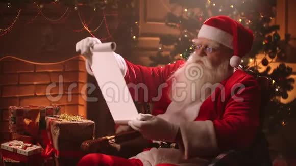 圣诞老人在一种神奇的气氛中阅读一张纸卷上面有一张儿童礼物清单视频的预览图