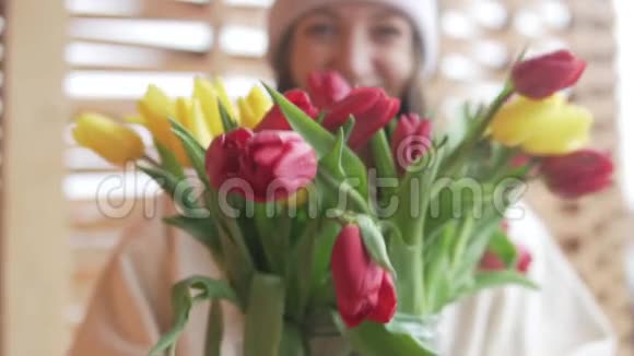 一个快乐的女人在镜头里捧出一束郁金香视频的预览图