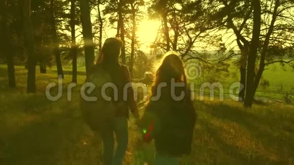 快乐的女人在度假时带着背包穿过树林举起双手远足女孩的团队合作免费旅客视频的预览图