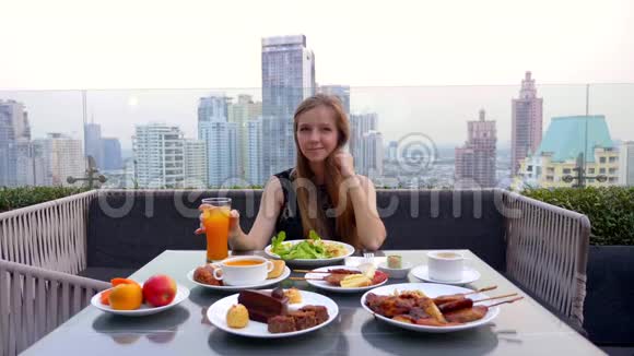 在室外屋顶餐厅妇女坐在桌上享用食物和饮料视频的预览图