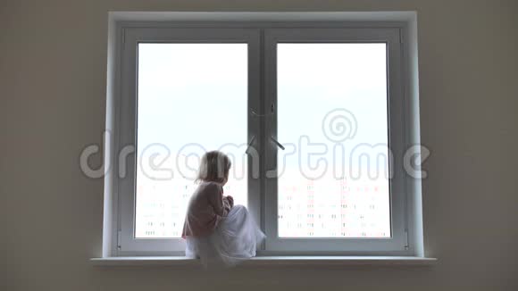 母亲来到坐在窗边的孤独的女儿身边视频的预览图