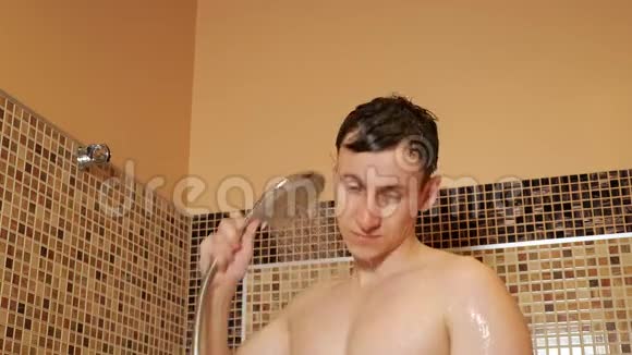 年轻人拿着淋浴头洗澡视频的预览图