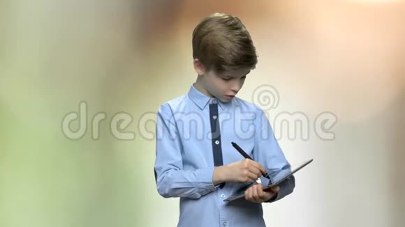 聪明的小男孩用数字平板电脑学习视频的预览图