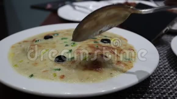 用勺子吃盘子里的千层面视频的预览图