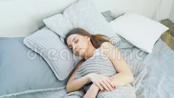 年轻迷人的女人在床上醒来休息和健康睡眠的概念视频的预览图