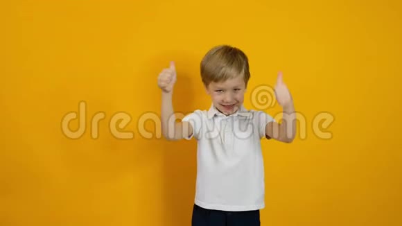 一个微笑着的五岁小男孩在黄色的背景上视频的预览图