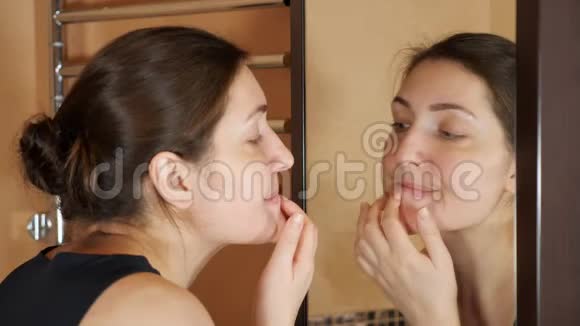 浴室里的小女孩看着镜子前的粉刺视频的预览图