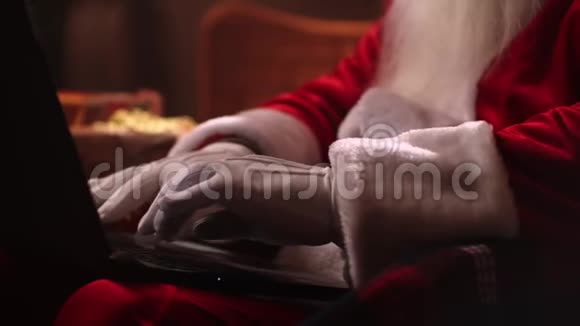 手的特写一个留着白胡子的年长圣诞老人坐在椅子上从事网上银行业务视频的预览图