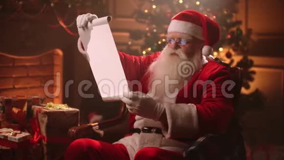 圣诞老人拿着羊皮纸的旧卷轴一封信空白用卷轴纸微笑圣诞老人圣诞老人名单视频的预览图